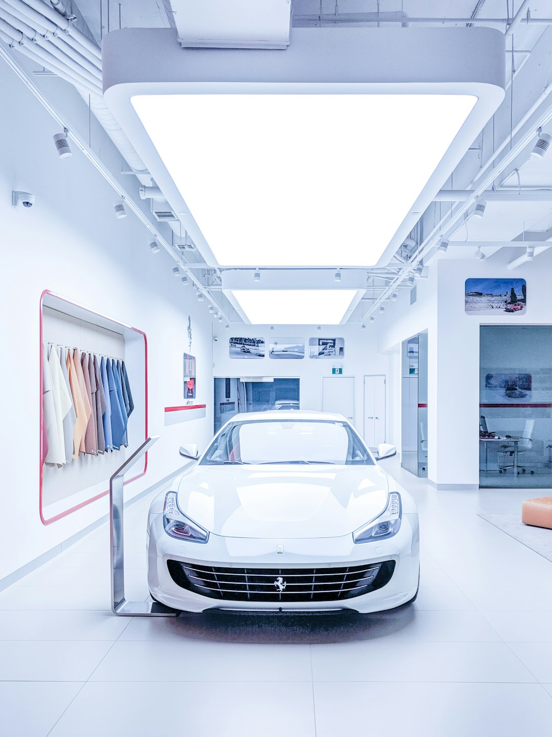 A white sports car parked inside a modern showroom.